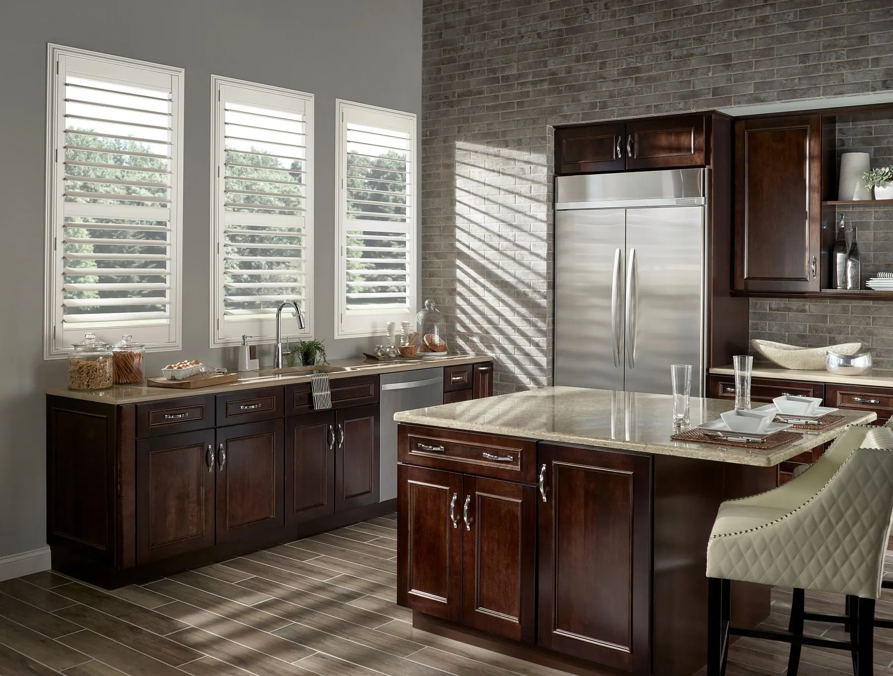 White plantation shutters with open louvers on three kitchen windows over dark wood cabinets.